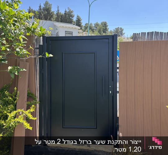 שער מתכת שחור במסגרת עץ חום